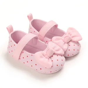 Detail view of soft-sole pink polka dot baby walking shoes with a decorative bow