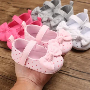 Close-up of pink polka dot baby girl princess shoes with a large bow