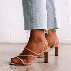 Elegante beige Riemchensandalen mit Blockabsatz, kombiniert mit hellen Fransen-Jeans.