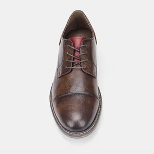 Top view detail of brown burnished leather men's dress shoe with contrast red tongue