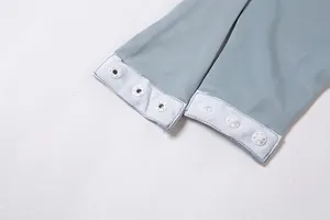 Gros plan détaillé montrant la fermeture à boutons-pression d'un body bleu doux