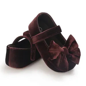 Close-up detail of dark burgundy velvet baby girl Mary Jane walking shoes with bow