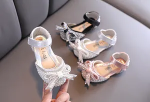 Vista macro dettagliata di scarpe da principessa per bambina con strass, perle e un fiocco elegante.