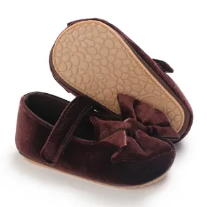 Close-up of burgundy velvet baby girls princess shoes with non-slip sole and elegant bow