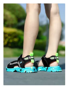 Detailansicht der schwarzen Kinder-Sandalen mit blauer Camo-Sohle und Neon-Akzenten.