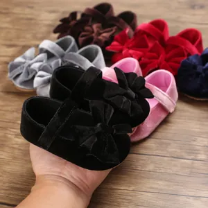Close-up of velvet baby girl shoes with big bows showing various available colors