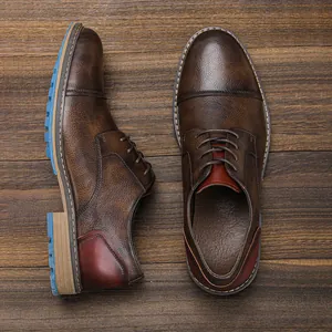 Men's brown burnished leather business casual shoes on a rustic wooden background