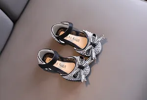 Dettaglio macro di scarpe da principessa nere per bambine con perle e strass brillanti