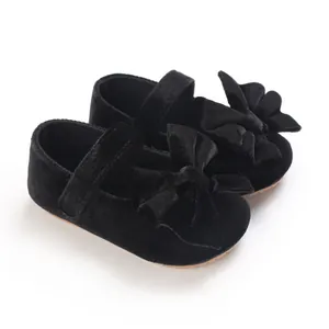 Detailed macro shot of black velvet baby girl Mary Janes with a large elegant bow