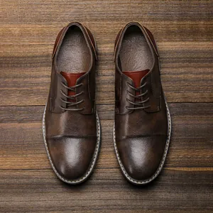 Detailed top-down view of classic brown business casual leather shoes on wooden background.