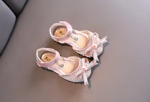 Vista dettagliata delle scarpe da principessa rosa per bambine con perle e fiocchi strass