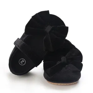 Close-up view of black velvet baby girl princess walker shoes with a large bow detail