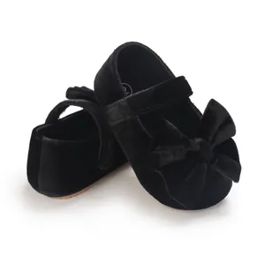 Close-up view of black velvet baby girl princess shoes featuring a large decorative bow
