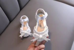 Dettaglio scarpe da principessa argento per bambina con fiocco di perle e strass