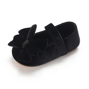 Detail view of black velvet baby girl princess shoes with a large decorative bow