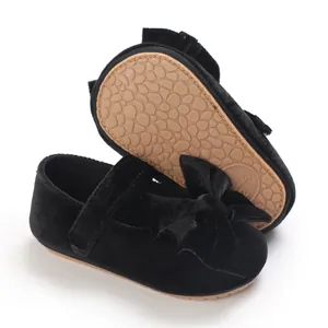 Detailed view of black velvet baby girl shoes featuring a soft non-slip sole and bow