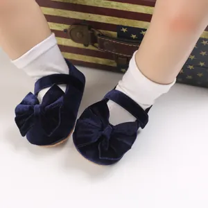 Close-up detail of navy blue velvet baby girl princess shoes featuring a large bow.