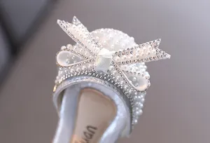 Dettaglio ravvicinato di scarpe da danza da principessa per bambina con fiocco di perle
