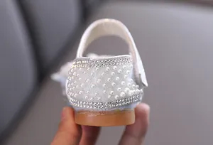 Primo piano del tallone di una scarpa da principessa per bambina con perle e strass