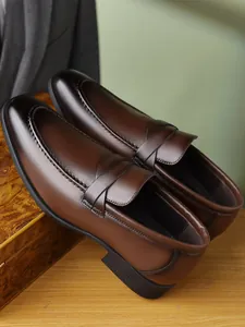 Close-up of brown leather penny loafers featuring fine stitching and a polished finish.