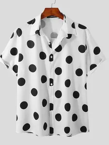 Detail of white men's short-sleeved shirt with large black polka dots on a wooden hanger