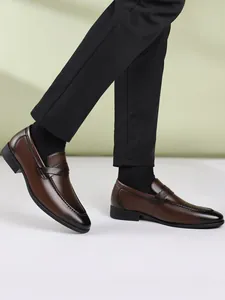 Side view detail of men's brown leather slip-on loafers with classic British stitching