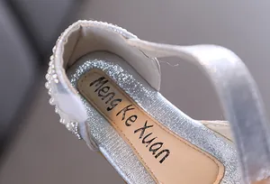 Dettaglio di scarpe da principessa glitter argento per bambine con perle e suola interna.