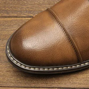 Detail view of premium textured brown leather and fine stitching on men's dress shoe