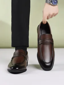 Detailed view of men's brown leather loafers with elegant stitching and slip-on design.
