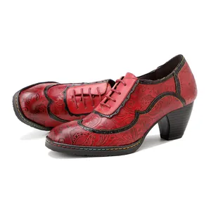 Détail de chaussures vintage à talons hauts en cuir rouge avec gaufrage floral et lacets