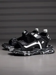 Detailed side view of stylish black boys' sandals with breathable mesh and camouflage sole