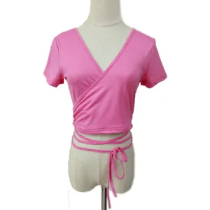 Vista dettagliata del crop top rosa con scollo a V e lacci incrociati sulla vita