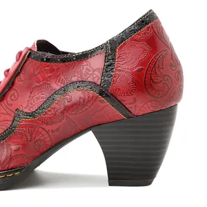 Détail d'une chaussure en cuir rouge gaufré avec motifs ethniques et coutures