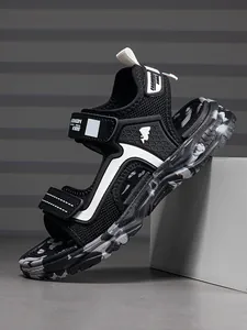 Detailed side view showing breathable mesh and sole of black and white boy sandals