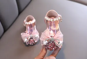 Vista macro detallada de zapatos de princesa rosa para niñas con lazo de purpurina y perlas
