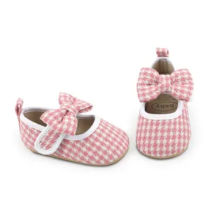 Detailed view of pink houndstooth baby girl walking shoes featuring a cute bow decoration