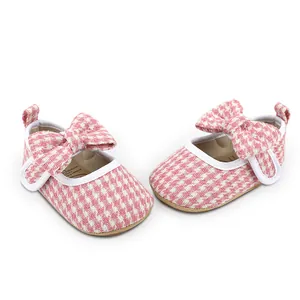 Detail showing pink houndstooth pattern and bow on baby girl walking shoes