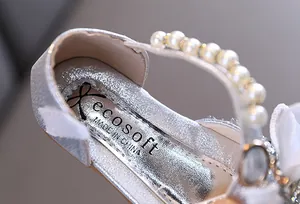 Primer plano de zapato de princesa plateado con purpurina y correa de perlas