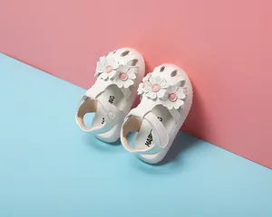 Detailansicht weißer Baby-Mädchen-Sandalen mit rosa Blütenakzenten und weicher Sohle.