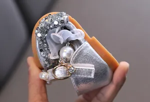 Detalle de zapatos de princesa plateados flexibles para niña con lentejuelas y perlas.