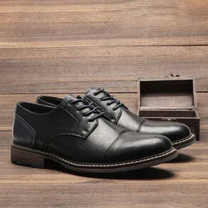 Classic black leather business dress shoes for men with cap toe design on wood background.