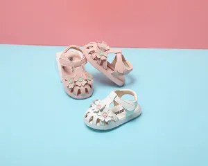 Detailansicht von Baby-Mädchen-Sandalen mit niedlichen Blumen-Dekorationen und weichen Sohlen.