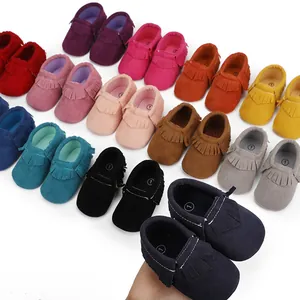 Detailansicht verschiedener bunter Wildleder-Babyschuhe mit Quasten für Neugeborene