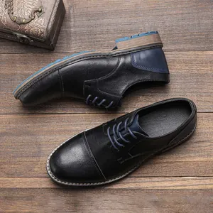 Detailed macro view of black leather dress shoes with blue accent details and stitching texture