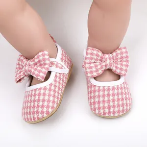 Detailed close-up of pink houndstooth pattern baby Mary Jane shoes with large bows