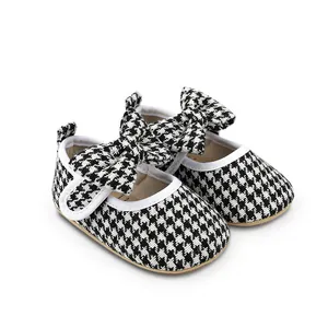 Detailed view of black and white houndstooth baby girl walking shoes with bow