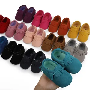 Makro-Detail von weichen Wildleder-Babyschuhen mit Fransen in verschiedenen bunten Farben