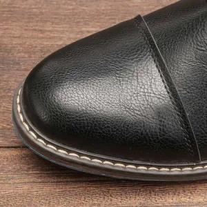 Close-up detail of black leather texture and stitching on men's business dress shoe
