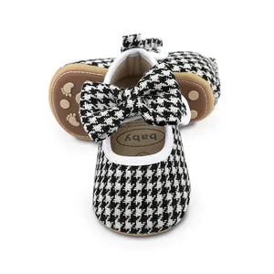 Close-up view of breathable houndstooth pattern baby shoes with elegant bow detail.