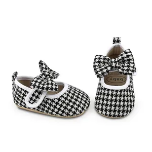 Close-up detail of anti-slip baby walking shoes with houndstooth pattern and big bow
